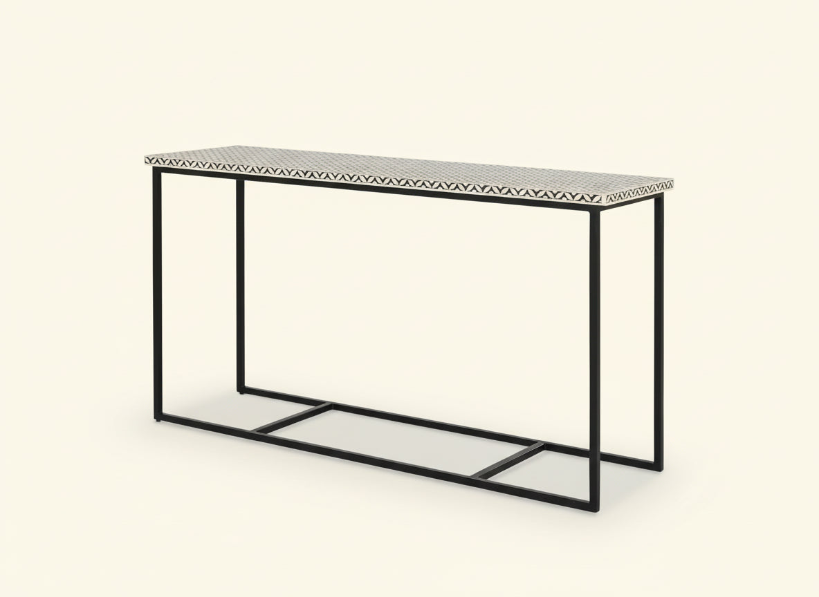 Console table with black metal frame and patterned top on a white background