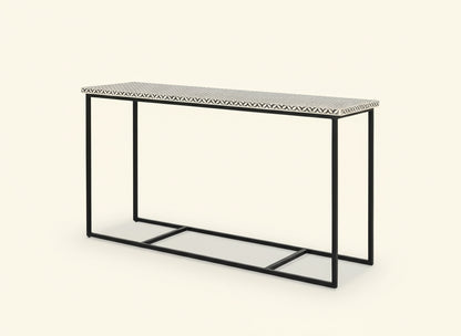 Console table with black metal frame and patterned top on a white background