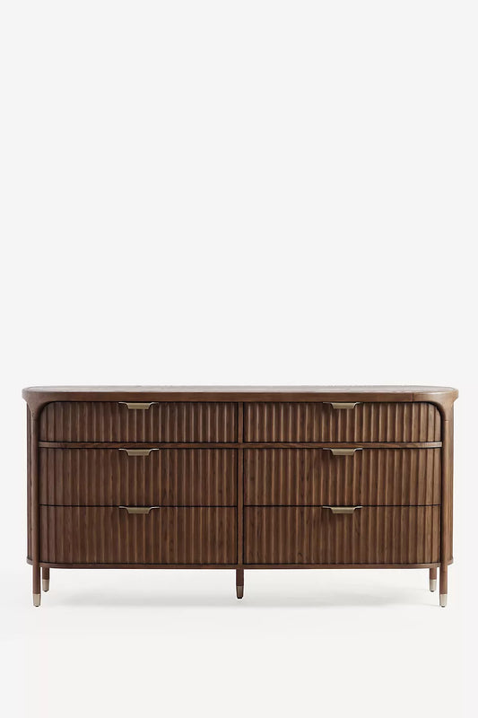 This appears to be a wooden six-drawer dresser, possibly from the brand Hansa Handicraft. It has a sleek, modern design with vertical grooves on the drawer fronts and elegant brass-finished handles.