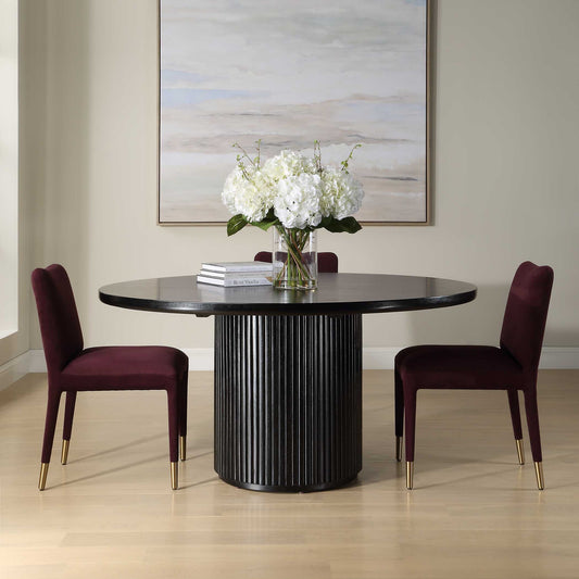 Dining room with a black round table and two purple chairs, featuring a vase of white flowers.