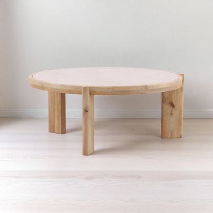 Round wooden coffee table with a white cushion on a plain background