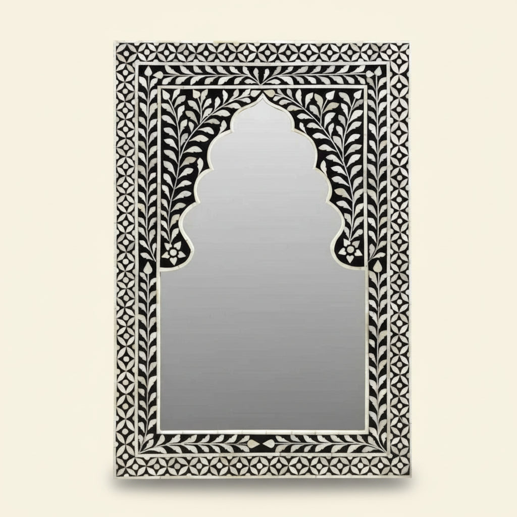 Decorative mirror with intricate black and white frame on a white background